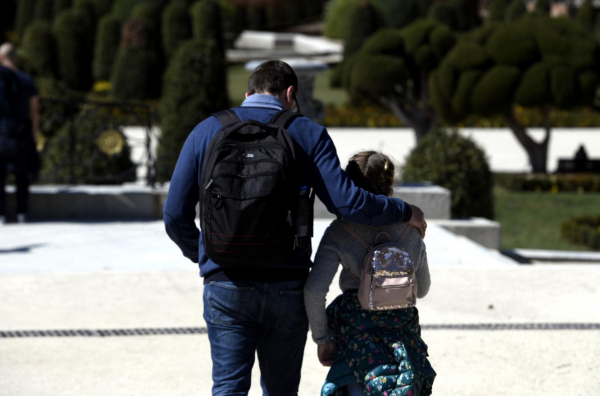 Un padre junto a su hija pasean por el Parque del Retiro en el primer día sin colegio