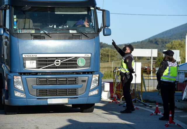 Un agente da el alto a un camión en un punto fronterizo entre Portugal y España donde están realizando controles de movilidad, a 5 de abril de abril de 2021, en Zarza la Mayor, Cáceres, (España). En el dispositivo, puesto en marcha entre los puntos de Mon