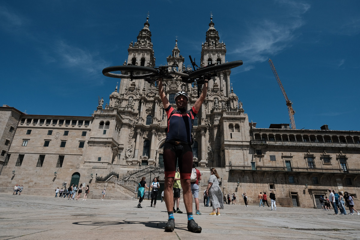 Archivo - Un peregrino portugués levanta su bicicleta al finalizar el Camino de Santiago, frente a la Catedral de Santiago, a 6 de junio de 2021, en Santiago de Compostela, A Coruña, Galicia, (España).