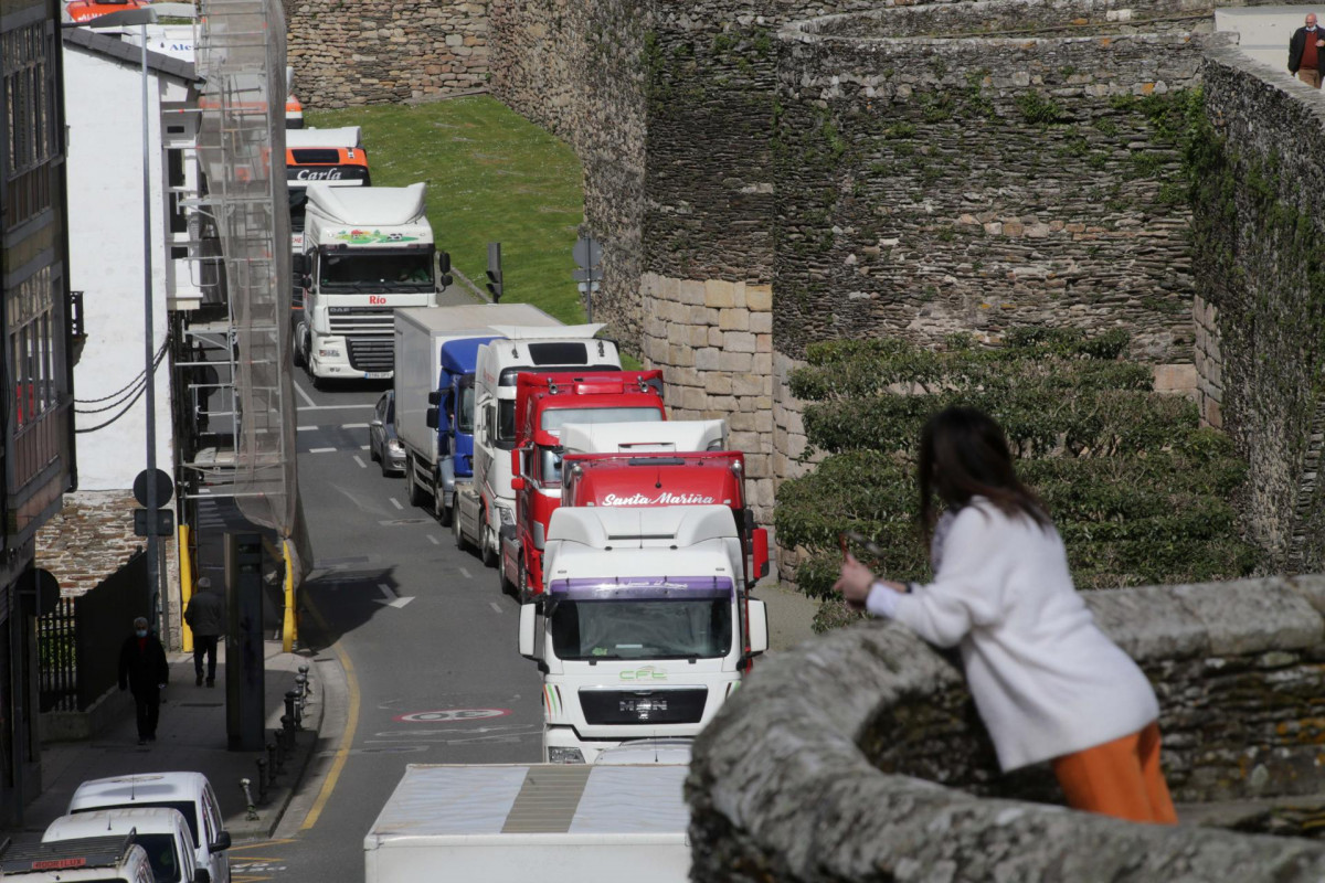 Una mujer observa el paso de los camiones desde el adarve de la Muralla, en una marcha lenta que ha salido desde el polígono de As Gándaras para pasar por varias localizaciones del centro de la ciud