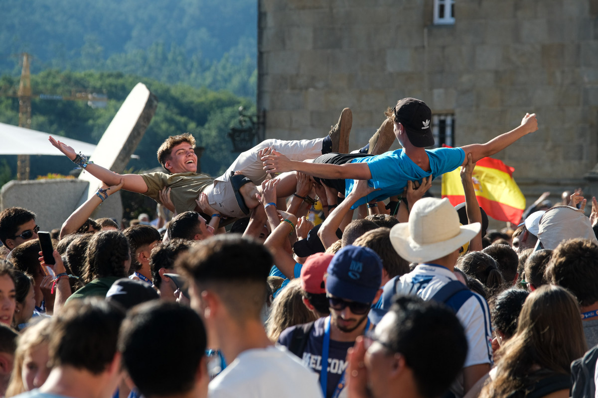 Dos jóvenes son levantados en brazos durante la inauguración y acto de acogida de la peregrinación europea de jóvenes 2022, en el Obradoiro de Santiago, a 3 de agosto de 2022, en Santiago de Compo