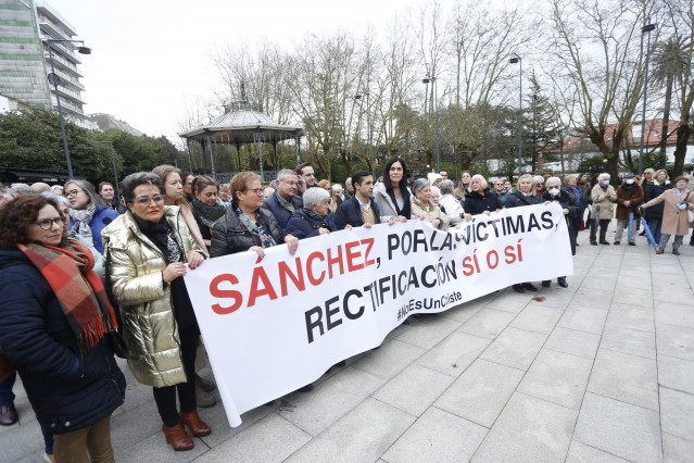 El presidente del PP de Ferrol, José Manuel Rey Varela (5i), y la secretaria general del PP gallego, Paula Prado (c), sujetan una pancarta que reza 'Sánchez, por las víctimas, rectificación sí o sí #NoEsUnChiste' durante la concentración convocada por el