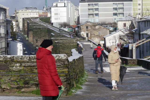 Archivo - Varias personas pasean sobre una ligera capa de nieve en la muralla romana de Lugo, a 18 de enero de 2023, en Lugo, Galicia (España). La cota de nieve está en 400 metros y ha sido acompañada por un descenso de las temperaturas. La situación más