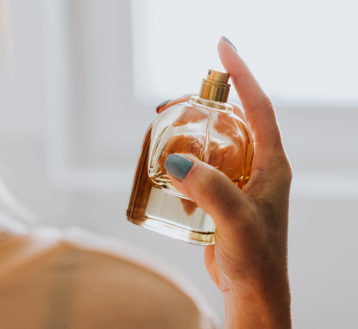 Archivo - Mujer con un perfume en su mano.