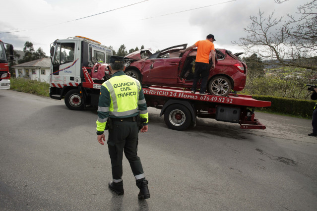 Un Guardia Civil vigila la retirada del coche siniestrado, en el accidente, por una grúa, a 1 de abril de 2023, en Xove, Lugo, Galicia.