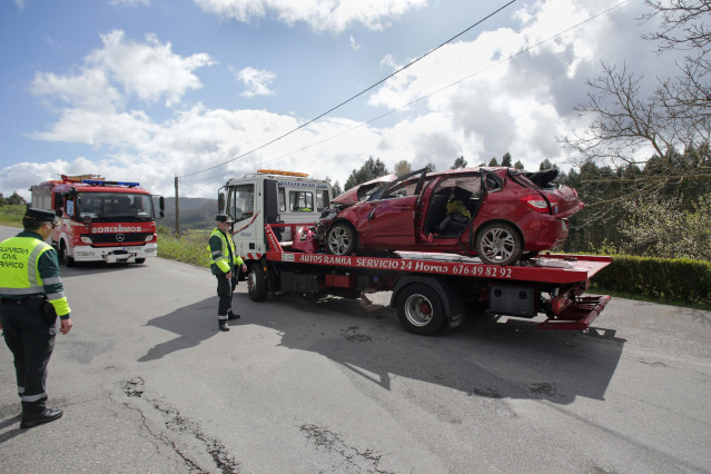 Efectivos de Guardia Civil vigilan la retirada del coche siniestrado, en el accidente, por una grúa, a 1 de abril de 2023, en Xove, Lugo, Galicia,