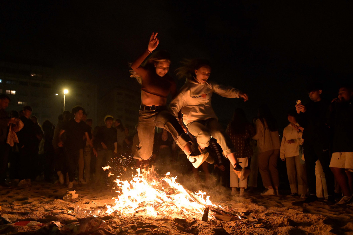 Archivo - Varios jóvenes saltan una hoguera en la noche de San Juan