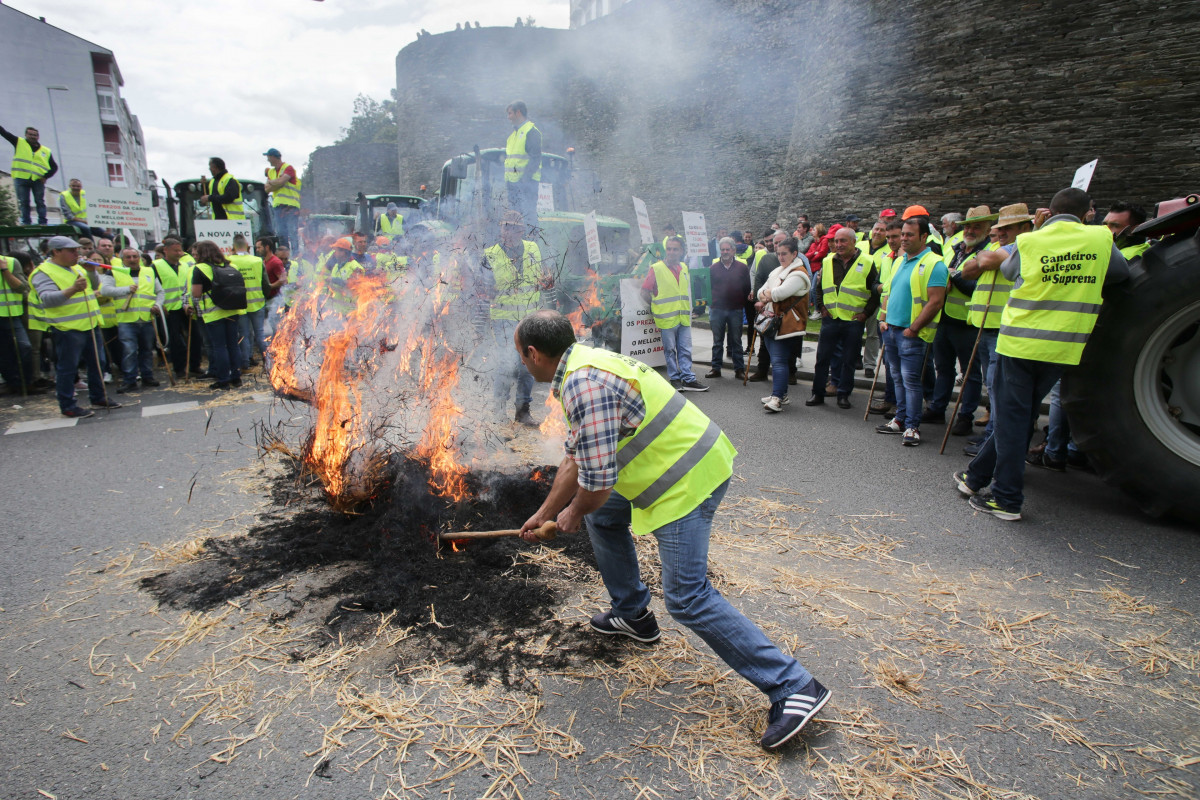 Un ganadero hace una hoguera con paja durante una manifestación en la Muralla de Lugo, a 11 de mayo de 2023, en Lugo, Galicia (España). Convocada por la Asociación de Productores de Ternera Suprema