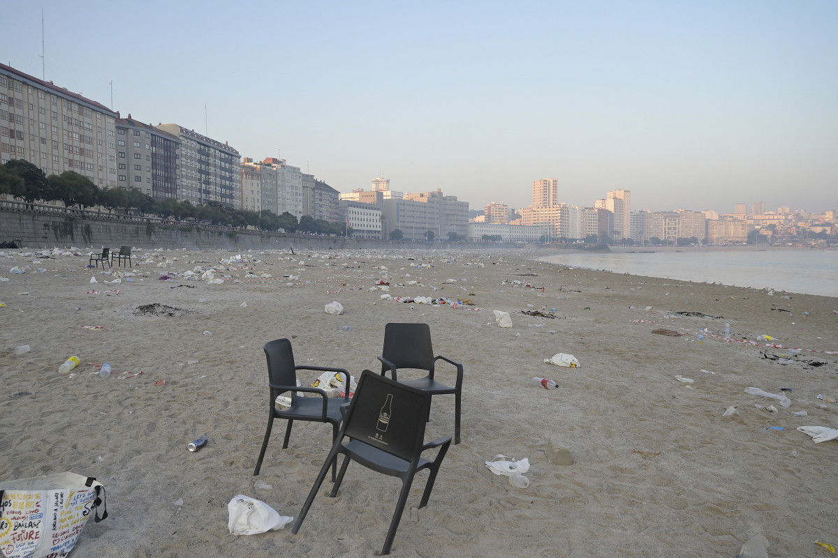 Unas sillas en la playa de Orzán con restos de basura alrededor después de la celebración de las hogueras de la noche de San Juan, a 24 de junio de 2023, en A Coruña, Galicia (España). La playa d