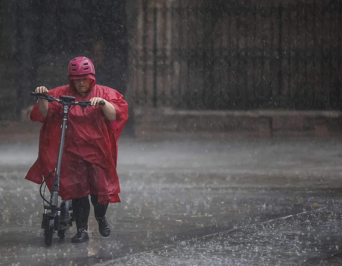 Una persona camina bajo la lluvia, a 15 de septiembre de 2023, en València, Comunidad Valenciana (España). Las tormentas, en algunos casos de intensidad fuerte, están recorriendo durante las primer