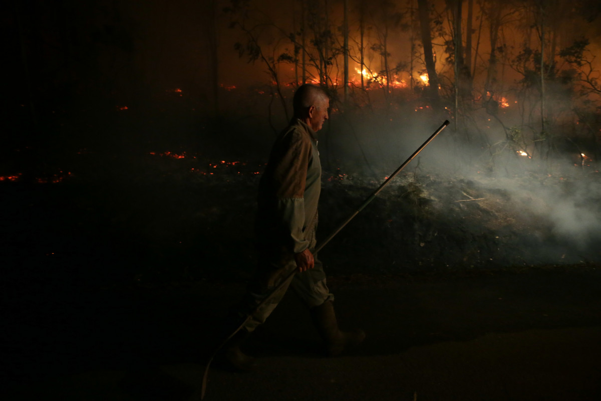 Vecinos participan en las labores de extinción del incendio, a 12 de octubre de 2023, en Vidal, Trabada, Lugo, Galicia (España).