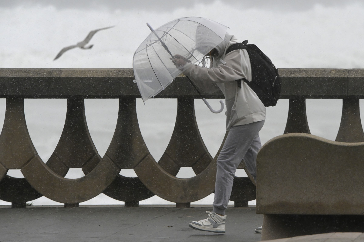 Una persona se protege de la lluvia y el viento con un paraguas, a 20 de octubre de 2023, en A Coruña, Galicia (España). La Xunta ha activado para hoy la alerta roja por temporal costero en el litor