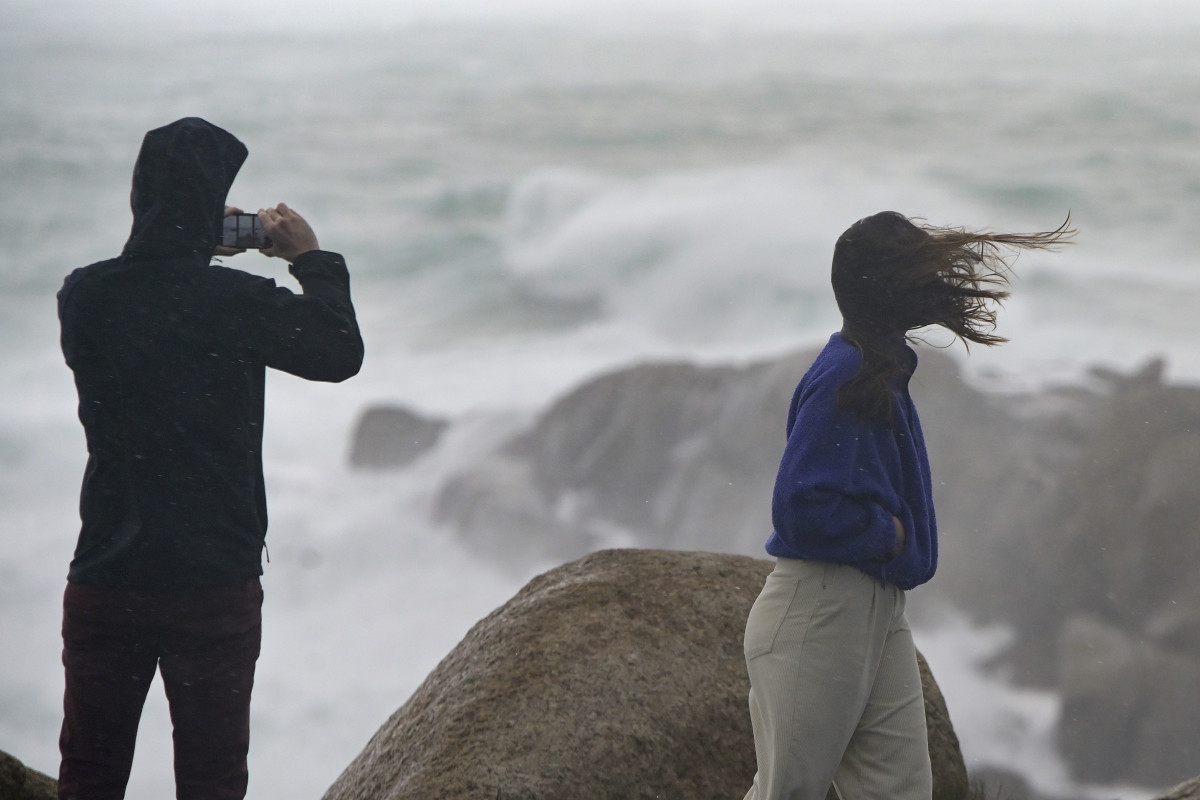 Una persona fotografía el mar embravecido, mientras el viento mueve la melena a su acompañante, a 4 de noviembre de 2023, en A Coruña, Galicia (España). La Agencia Estatal de Meteorología (AEMET)