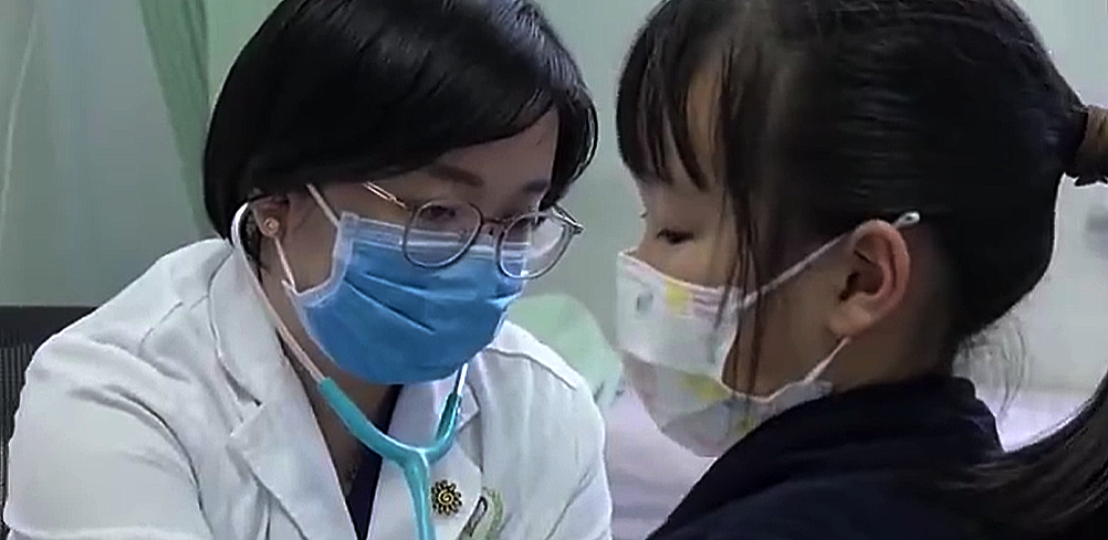 Mu00e9dica atendiendo a una niu00f1a en un hospital chino en una imagen publicada por la televisiu00f3n estatal CCTV el du00eda 24 de noviembre