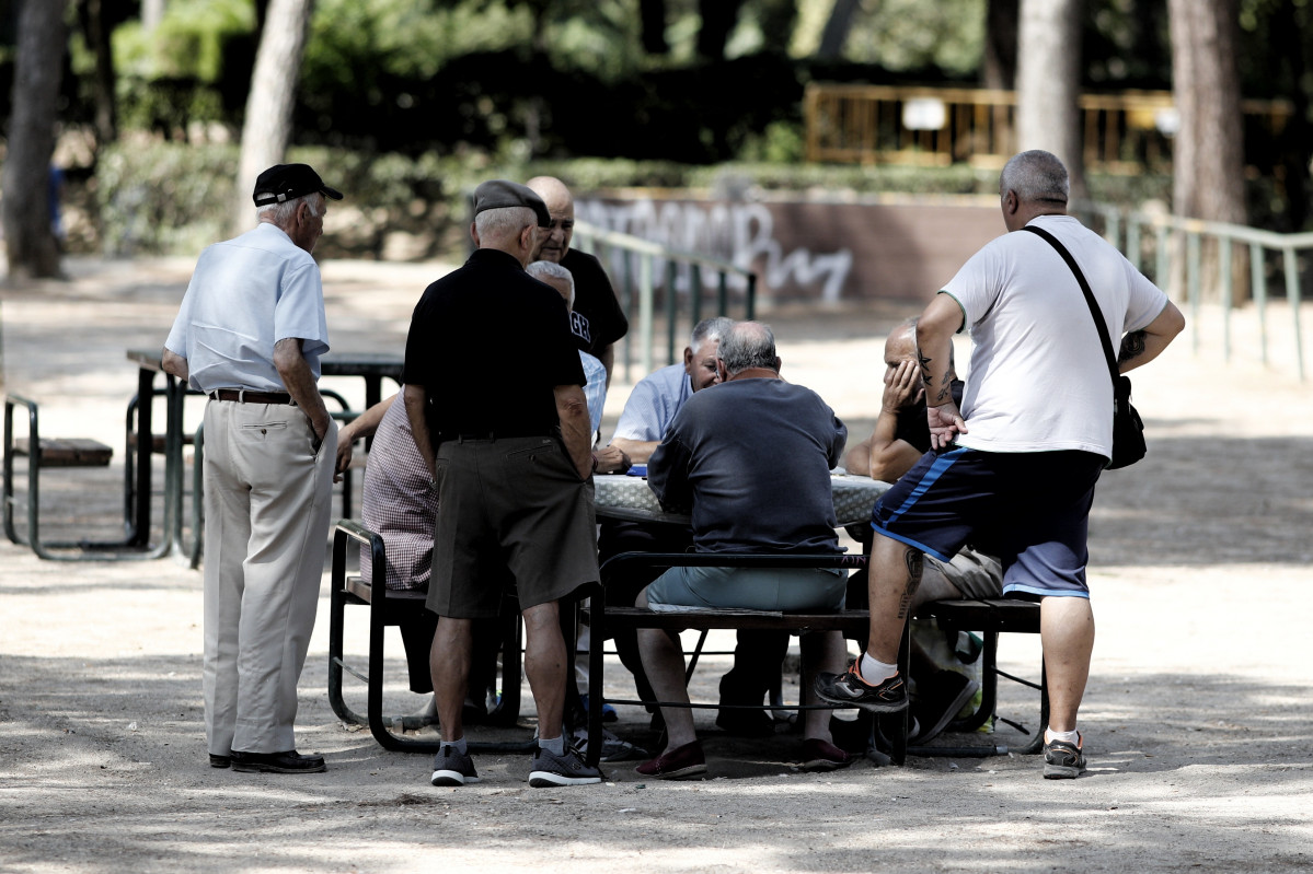 Archivo - Varios pensionistas juegan al dominó en un parque de Madrid.