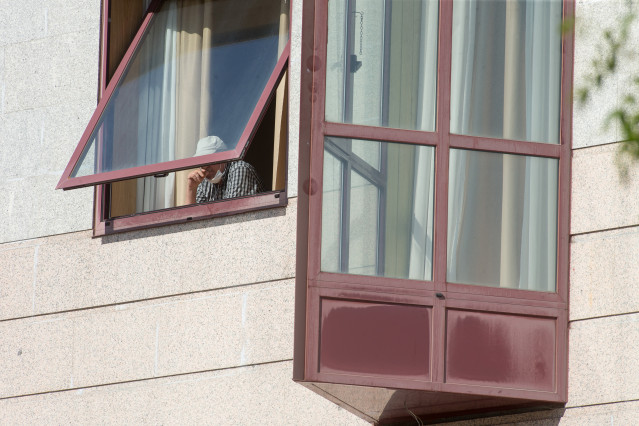 Archivo - Una persona se asoma por la ventana de la residencia de mayores DomusVi de Outeiro de Rei en Lugo, Galicia (España), a 8 de septiembre de 2020