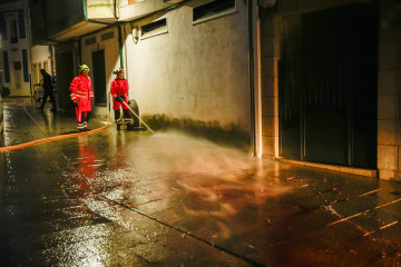 Bomberos limpian la calle de Vilaxoán de Arousa, en Vilagarcía de Arousa (Pontevedra), donde un varón asesinó supuestamente a su cuñado de una puñalada en la tarde de este viernes, 26 de mayo de