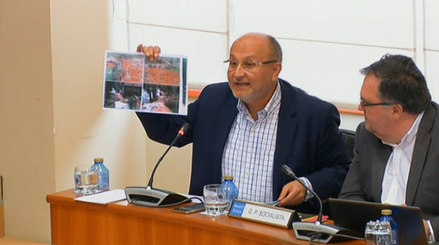 El socialista Abel Losada muestra fotografías durante el debate sobre la mina