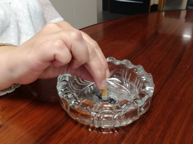 Apagando un cigarrillo. Cenicero. Tabaco.