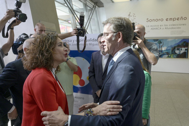 La ministra de Hacienda en funciones, María Jesús Montero y  el presidente de la Xunta de Galicia, Alberto Núñez Feijóo, se saludan a su llegada a la presentación del Anuario 2019 en la sede de Afundación Obra Social ABANCA.
