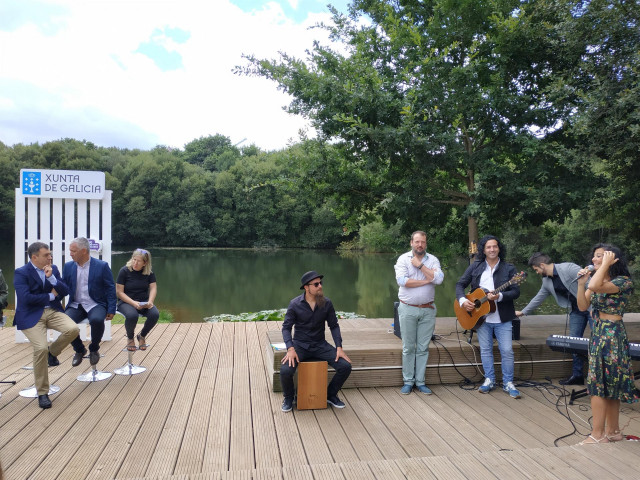 A la izquierda, el conselleiro de Cultura escuchando al grupo A Roda junto con Lucía Pérez.