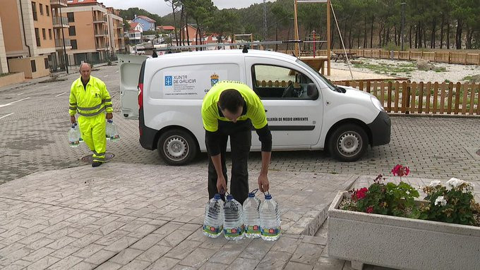 Operarios del Concello de Corme repartiendo agua em botella