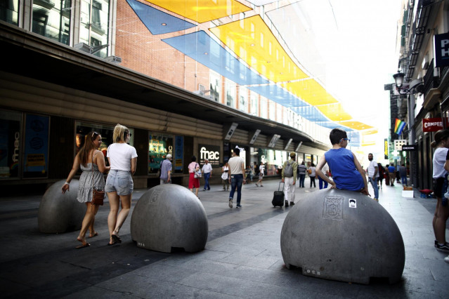Turistas y vecinos de la zona Centro de Madrid pasean por la calle Preciados bajo la sombra gracias a los toldos instalados