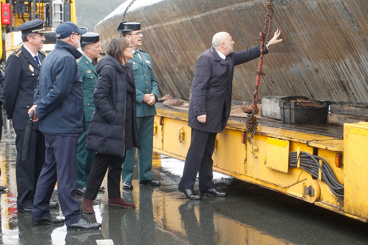 El delegado  Gobierno en Galicia, Javier Losada y la subdelegada,  Maica Larriba, ante el narcosubmarino hundido en Cangas (Pontevedra) y que fue reflotado por dos grandes grúas.