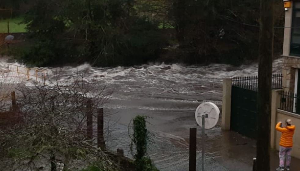 Vecinos tomando fotos del desbordamiento del Río Pedras