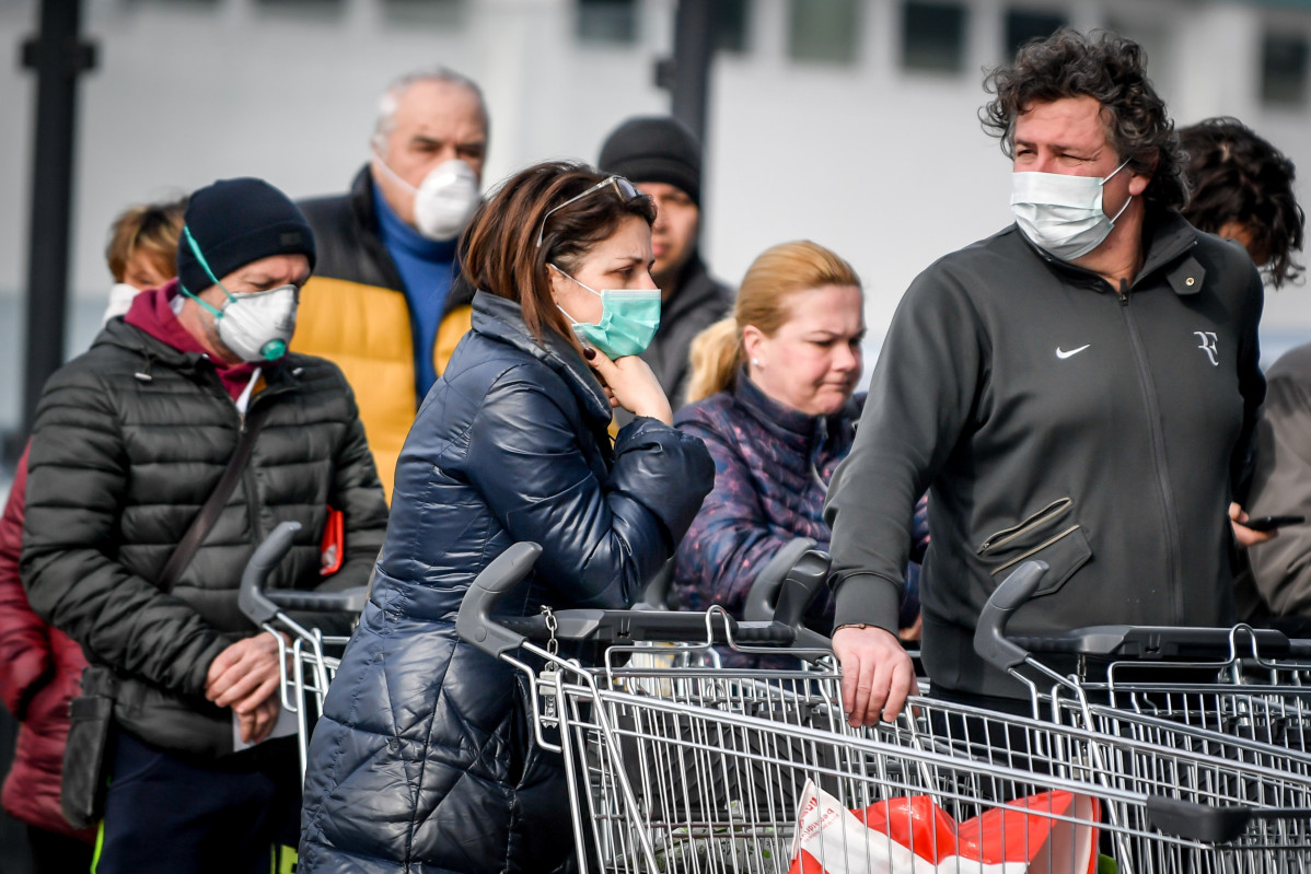 Persoas con máscaras cirúrxicas fan cola diante dun supermercado en zona de Italia onde se detectou a propagación do coronavirus Foto de  Claudio Furlan