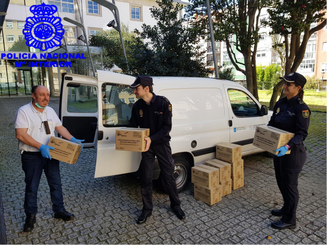 Agentes de la Policía Nacional entregan cajas con pares de guantes