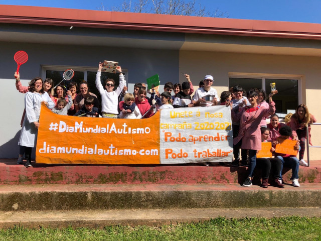 Alumnos y profesores del colegio de la Fundación Menela, con un cartel alusivo al Día Mundial del Autismo en 2020, y a la campaña 'Podo Aprender, Podo Traballar'.