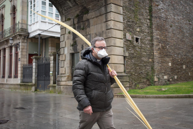 Un cura camina con una palma bendecida durante el Domingo de Ramos en Lugo tras la suspensión de la Semana Santa por el estado de alarma del coronavirus, en Lugo/Galicia (España) a 5 de abril de 2020