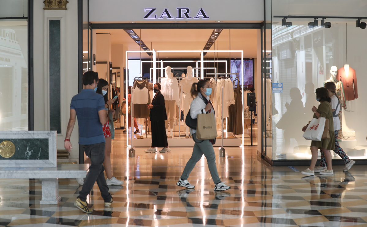 Varias personas pasan junto a una tienda Zara