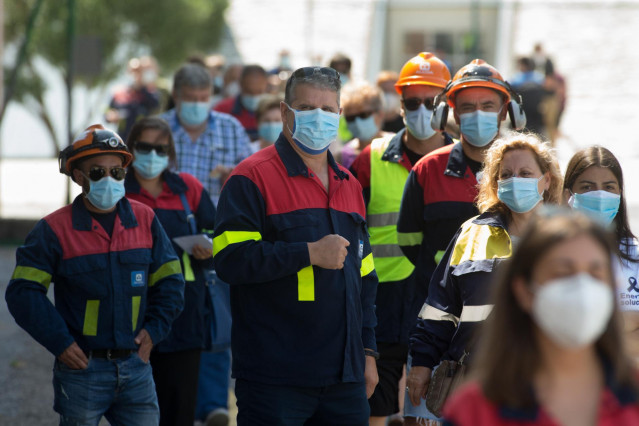 Trabajadores de Alcoa ataviados con el uniforme de la fábrica acuden a votar en las elecciones autonómicas de Galicia en el Pabellón Os Castros, en Burela