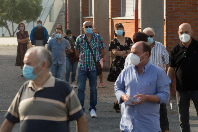 Varias personas hacen cola para votar en las elecciones autonómicas de Galicia en la población de Burela
