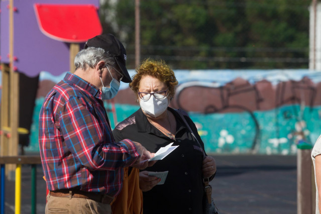 Dos personas con mascarillas ante el Pabellón Os Castros, en Burela (Lugo).