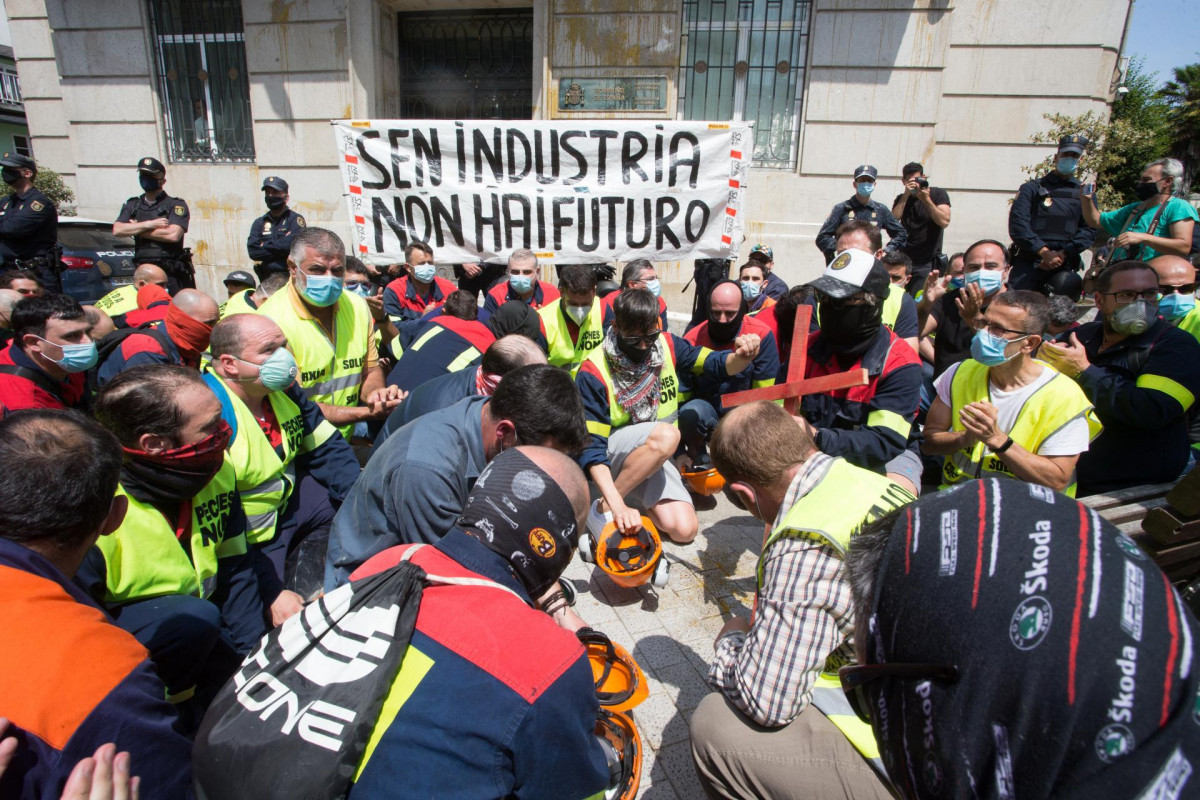 Manifestantes golpean sus cascos como signo de protesta a las puertas de la Subdelegación del Gobierno en Lugo durante una concentración convocada por el comité de Alcoa San Cibrao, donde además h
