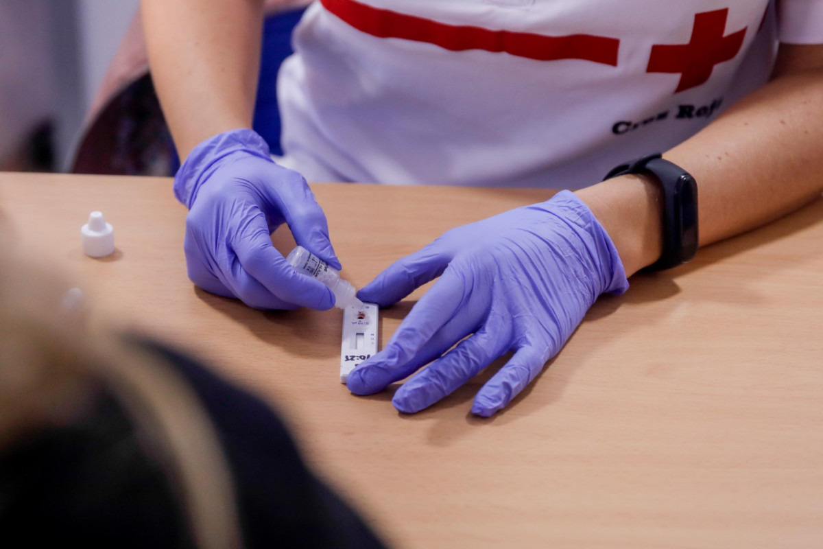 Personal sanitario de Cruz Roja muestra el resultado de un test rápido de detección de anticuerpos.