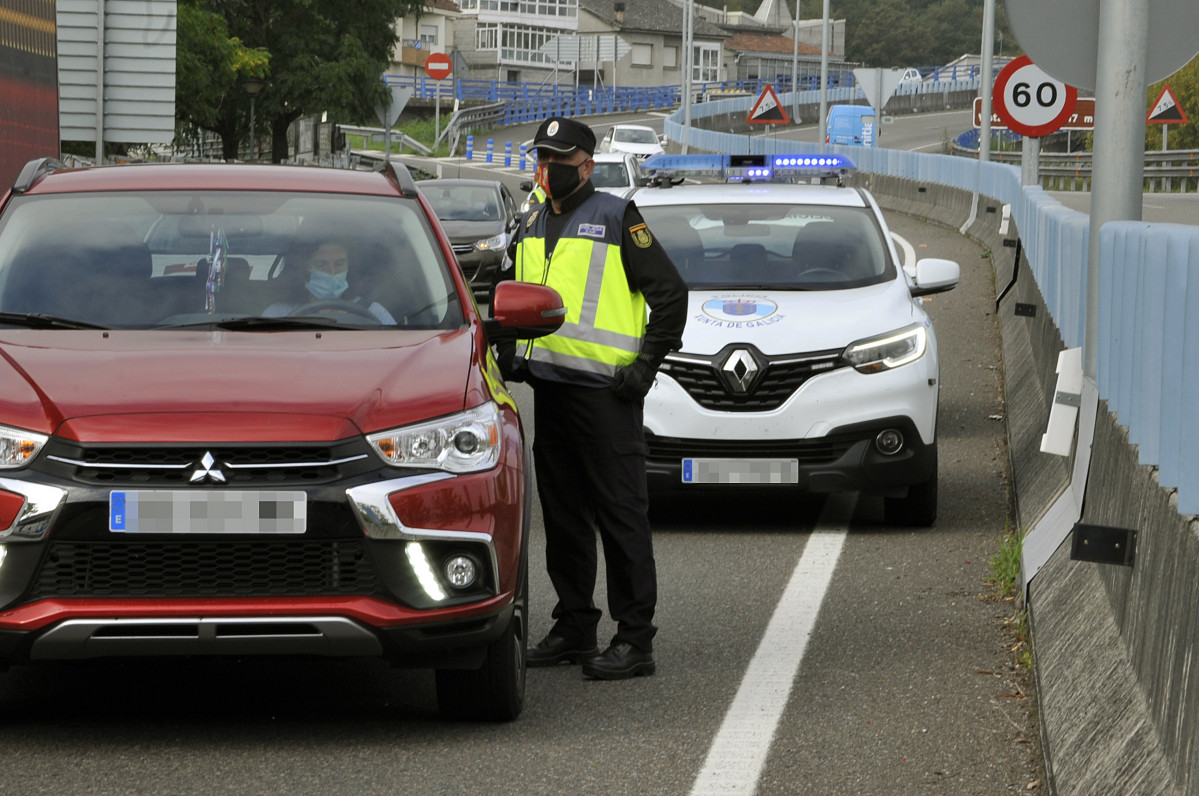 Un agente de la Policía Autonómica de Galicia en un control policial en la entrada a la ciudad de Ourense durante el primer día de su confinamiento debido al incremento de casos de Covid-19, en Our