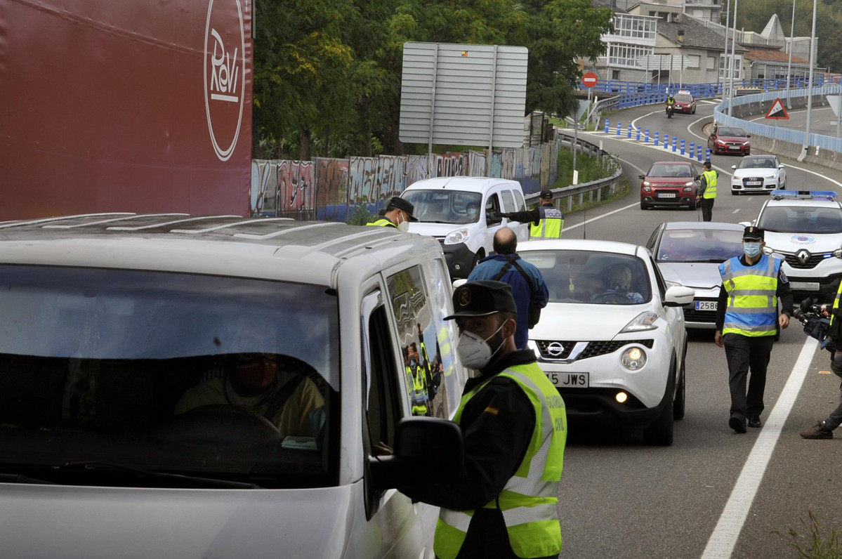 Agentes de la Guardia Civil y de la Policía Autonómica de Galicia trabajan en un control policial en la entrada a la ciudad de Ourense durante el primer día de su confinamiento debido al incremento