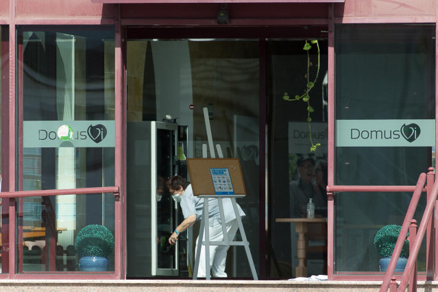 Un trabajador protegido es visto por uno de los cristales de la residencia de mayores DomusVi de Outeiro de Rei en Lugo, Galicia (España), a 8 de septiembre de 2020. La Xunta ha intervenido el geriátrico tras detectar 99 positivos más en covid-19, 94 de e