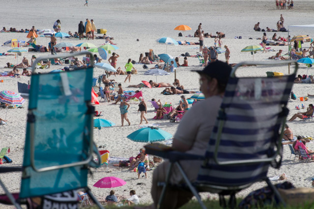 Una persona sentada frente a la playa en A Mariña (Lugo/Galicia) a 27 de julio de 2020