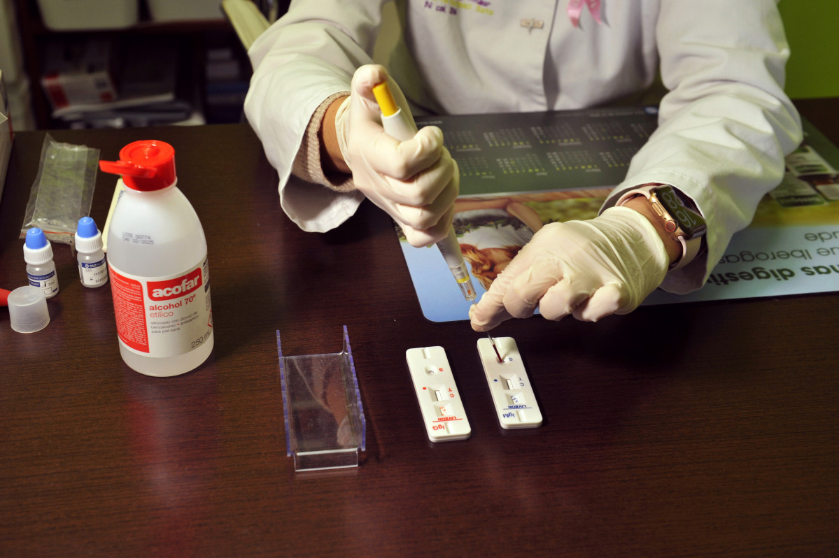 Una farmacéutica de la Farmacia Portal Martínez Soto introduce en una placa la muestra de sangre que ha tomado para realizar un test de cribado del coronavirus en Barbadás.