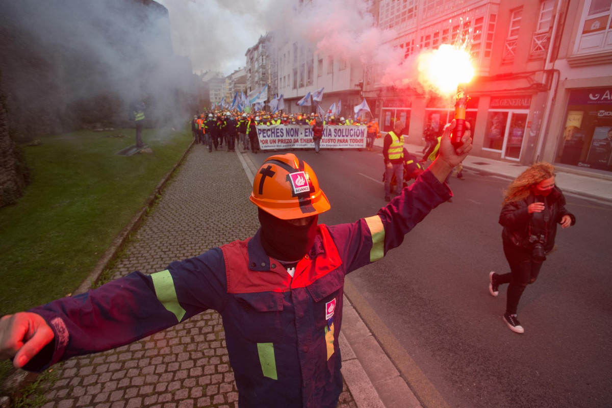 Un trabajador de la planta de Alcoa San Cibrao sostiene una bengala durante una concentración llevada a cabo por las calles de Lugo, Galicia, (España), a 24 de octubre de 2020.