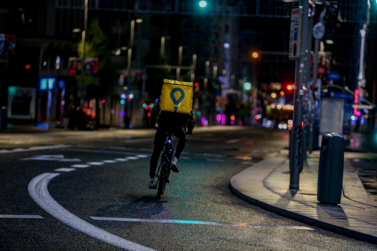 Un rider de Globo circula durante la primera noche de  toque de queda en Madrid (España), a 26 de octubre de 2020