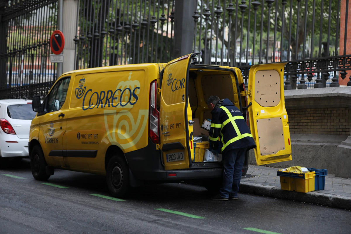 Un trabajador de Correos extrae de su furgoneta paquetes y cartas