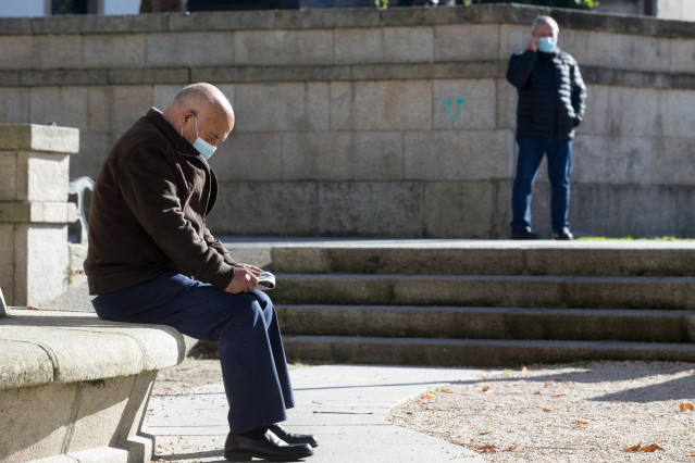 Una persona lee en un banco el mismo día de la entrada en vigor de nuevas restricciones impuestas por la crisis del Covid-19 en el municipio de Vilalba, Lugo, (España), a 21 de noviembre de 2020. Entre las medidas, además del cierre perimetral, se incluye