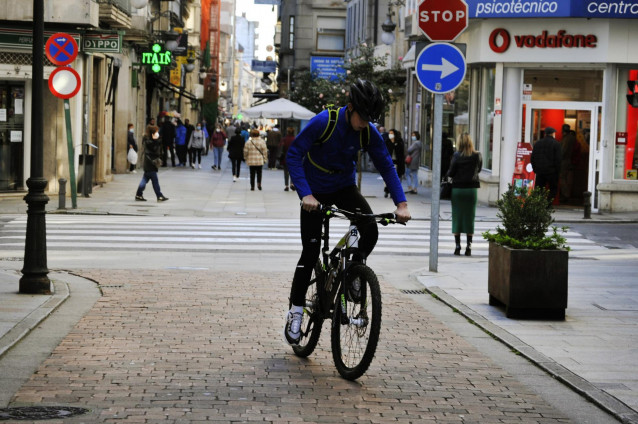 Una persona circula en bicicleta por una vía del centro el mismo día en que se levanta el cierre perimetral del municipio y se reabre la hostelería, en O Carballiño, Ourense, Galicia, (España), a 21 de noviembre de 2020. Esta nueva fase de desescalada se