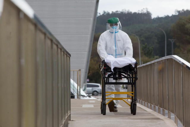 Un trabajador sanitario totalmente protegido traslada una camilla en las inmediaciones de la residencia de ancianos de San Cibrao donde se ha originado un brote de Covid-19, en San Cibrao, Lugo, Galicia, (España), a 9 de noviembre de 2020. En el centro la